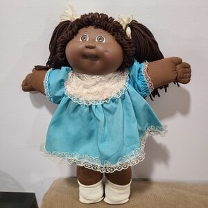 Vintage 1982 African American Cabbage Patch Kids doll wearing frilly blue dress